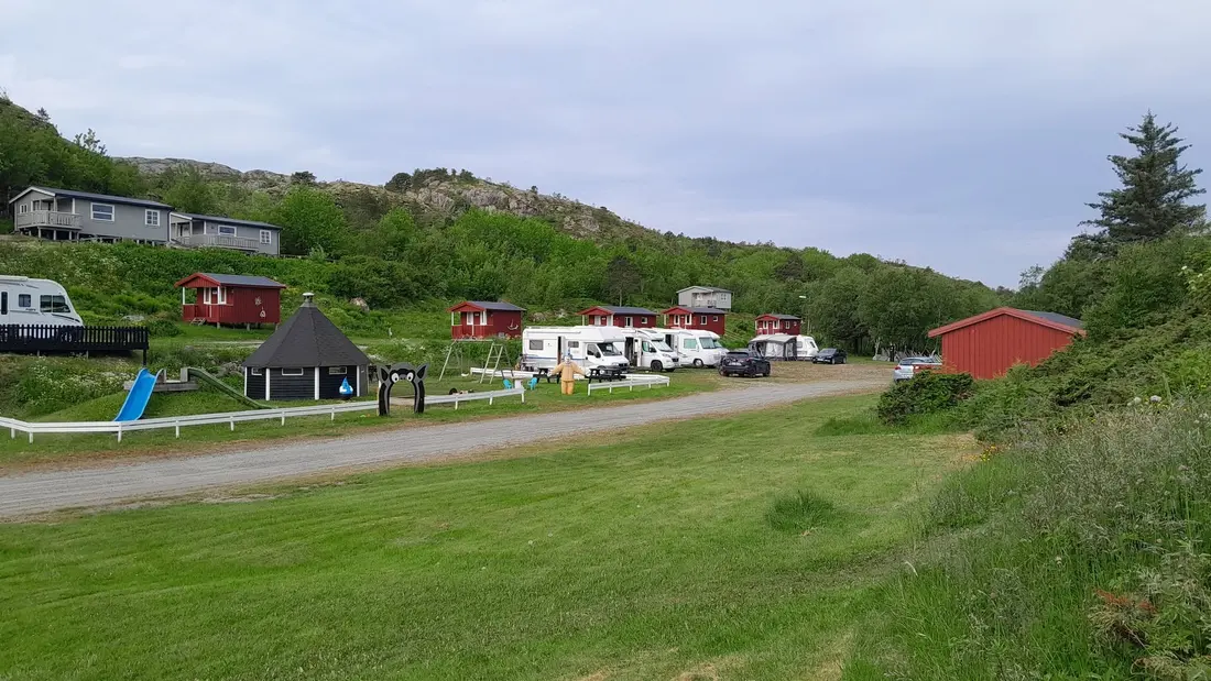 Røde hytter ved siden av lekeplassen på Aglen Camp og Bobilparkering